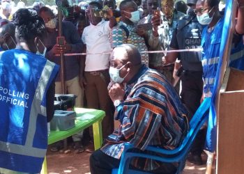 John Mahama picks up voter’s ID card.