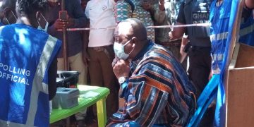 John Mahama picks up voter’s ID card.